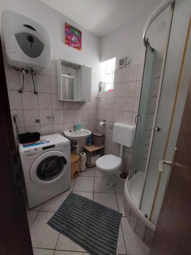 a bathroom with a washing machine and a sink at Apartment Marinetto in Stari Grad