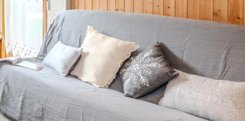 a gray couch with several pillows on it at Slow Chalet Thônes lake & mountain 15 min to ski lift balcony parking in Thônes