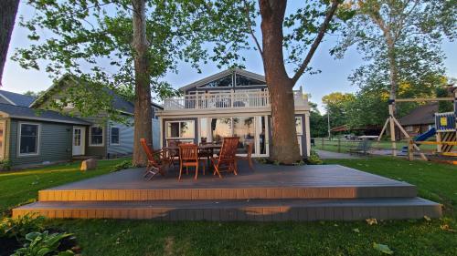 una terraza con mesa y sillas frente a una casa en Lake Of The Woods Sunset Shore, en Bremen
