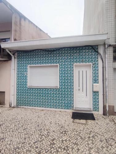a building with a white door on the side of it at Seventy House By Furabeach in Furadouro