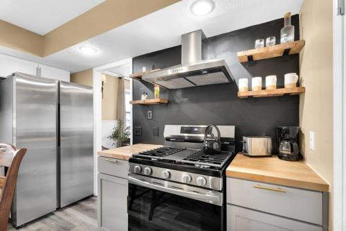 a kitchen with a stove and a stainless steel refrigerator at Small cozy ranch in Rantoul