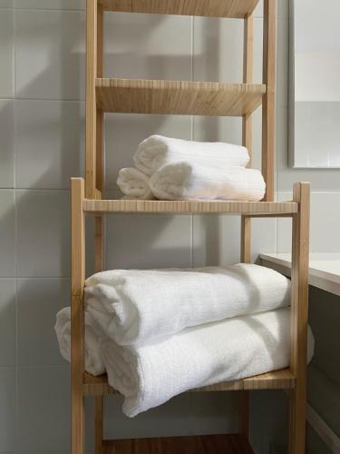 a wooden towel rack with white towels on it at Venice Home Free Parking in Mestre