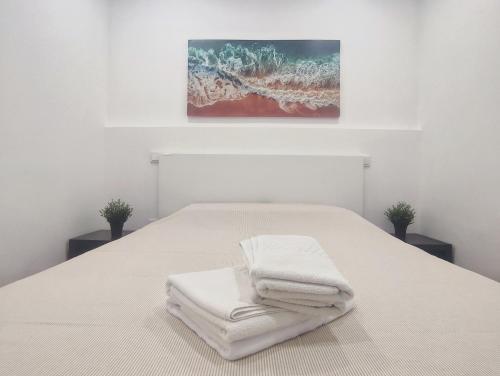 a bedroom with a bed with white towels on it at Seventy House By Furabeach in Furadouro
