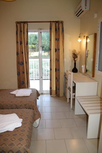 a room with two beds and a bathroom with a sink at Mediterranean Blue in Kavos