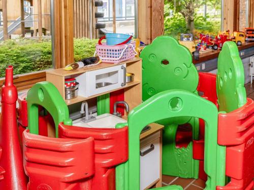 a toy kitchen with red chairs and a microwave at 12 person holiday park home in Hanstholm in Hanstholm