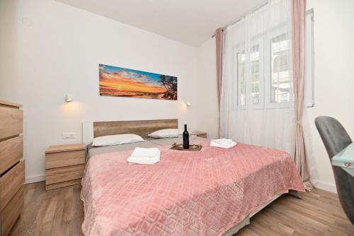 a bedroom with a bed with a red blanket at New, close to the beach apartment with terrace, grill, parking, 2-rooms in Trogir