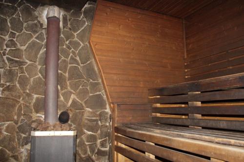 a sauna with a bench and a stone wall at Khatky Na Penkakh in Vorokhta