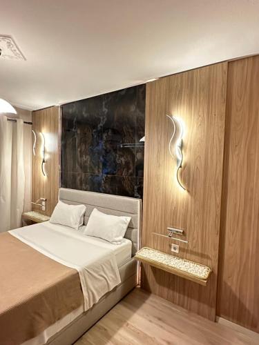 a bedroom with a bed and a wooden wall at Perikleous 5 Diamerisma KONDOULIS HOUSE in Kalabaka