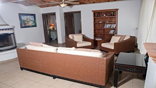 a living room with wicker furniture and a fireplace at Villa Meli 1 in Jocotepec