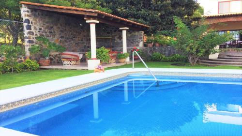 a swimming pool with a teddy bear in front of a house at Villa Meli 1 in Jocotepec