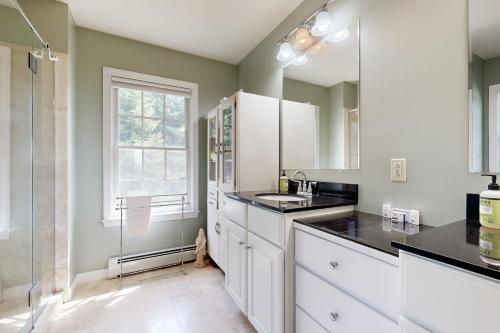 a kitchen with white cabinets and a sink and a window at East Boothbay Gardens in East Boothbay