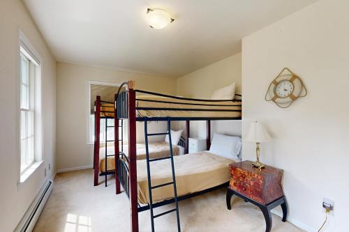 a bedroom with two bunk beds and a desk at East Boothbay Gardens in East Boothbay