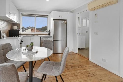 a kitchen with a table and chairs and a refrigerator at Prickly Pear Stays Jesmond - Short Term Accommodations in Jesmond