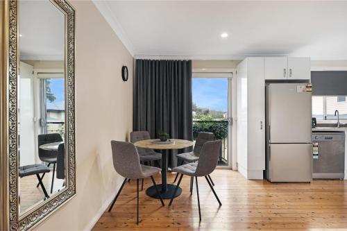 a dining room with a mirror and a table and chairs at Prickly Pear Stays Jesmond - Short Term Accommodations in Jesmond