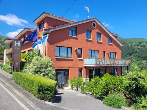 a large red building with a sign on it at Hotel Restaurante Canzana in Pola de Laviana