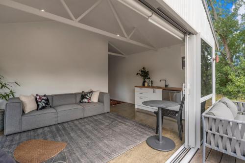 a living room with a couch and a table at The Landing Pad - Matakana Holiday Retreat in Matakana