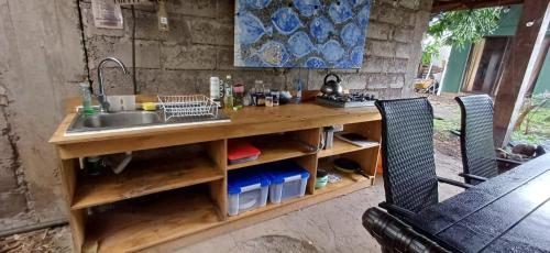 a kitchen with a sink and a counter with two chairs at Mata Nui Eco hostel in Hanga Roa