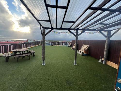 a patio with tables and benches on a roof at Fisherinn Guesthouse in Stokkseyri