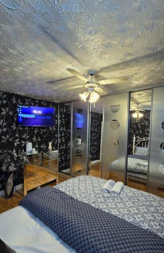 a bedroom with a bed and a tv on the wall at Ritchie Guest House in Wigan