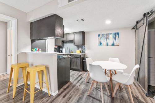 a kitchen with a table and yellow stools in a room at SoCo Chic Apartment Suites Close to Downtown in Austin
