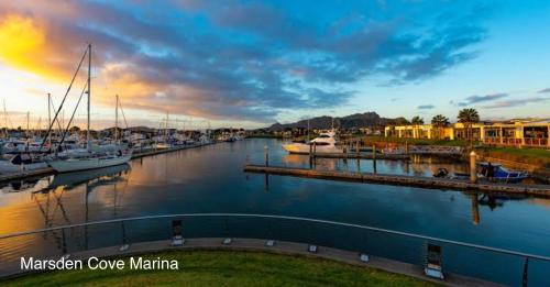a marina with boats in the water at sunset at Moko Hiwi Escape Ruakaka - Tūī Suite in Ruakaka
