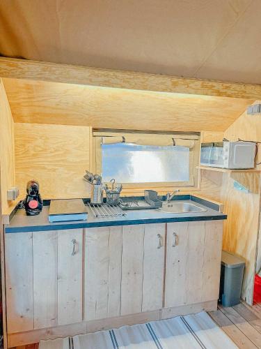 a kitchen with a sink and a microwave at Camping Miramar Playa - tienda familiar in Torredembarra