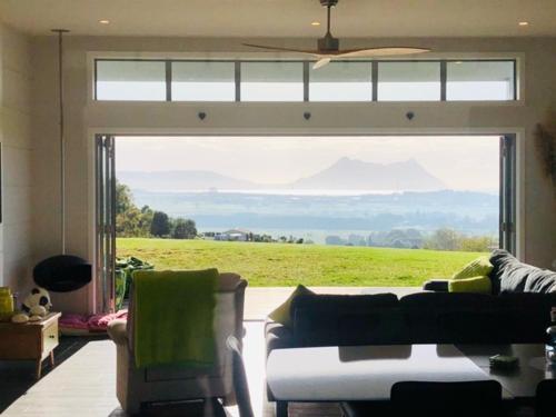 a living room with a large window with a view at Moko Hiwi Escape Ruakaka - Tūī Suite in Ruakaka