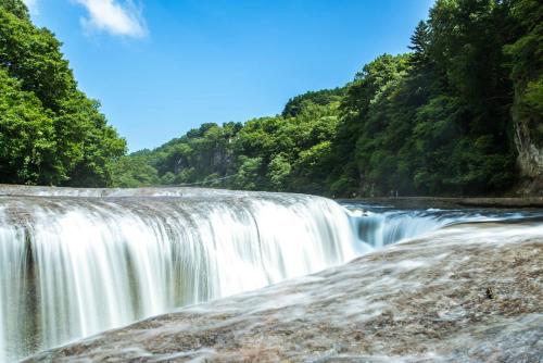 a waterfall in the middle of a river at 貸別荘たまゆら in Kawaba