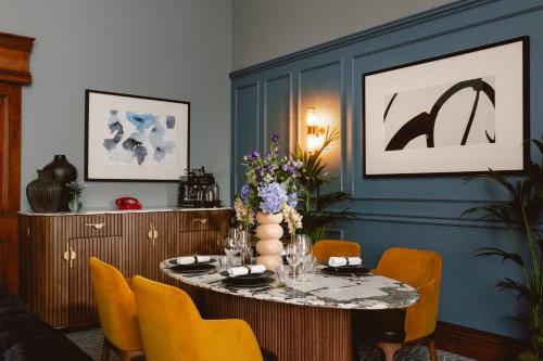 a dining room with a table and yellow chairs at Kimpton Clocktower by IHG in Manchester