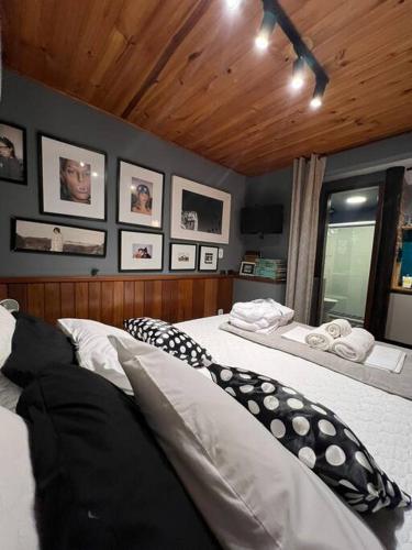 two beds in a bedroom with pictures on the wall at Casinha do Fotógrafo em Domingos Martins a 7km do Centro in Domingos Martins