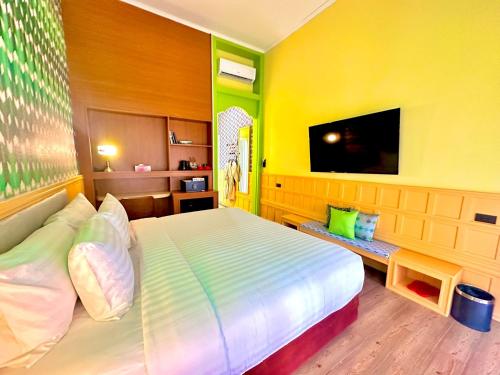 a bedroom with a large bed and a tv at Senglao Boutique Hotel Luang Prabang in Luang Prabang