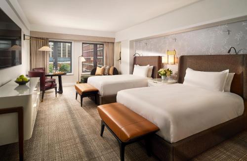 a hotel room with two beds and a living room at Mandarin Oriental, Boston in Boston