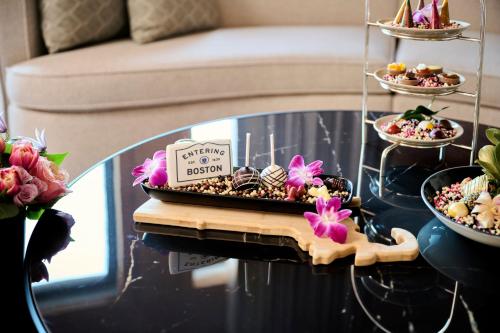 a table with a tray of desserts and flowers on it at Mandarin Oriental, Boston in Boston