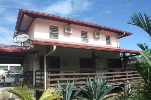 a house with a balcony and palm trees at la kasaloc in Saint-Laurent du Maroni