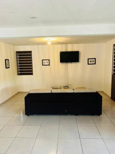 a room with two beds and a flat screen tv at la kasaloc in Saint-Laurent du Maroni