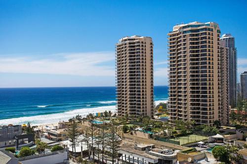 two tall buildings on the beach next to the ocean at Paradise Centre Apartments managed by Gchs in Gold Coast