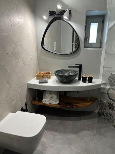 a bathroom with a sink and a toilet and a mirror at Casa Legko in Plaka Milou