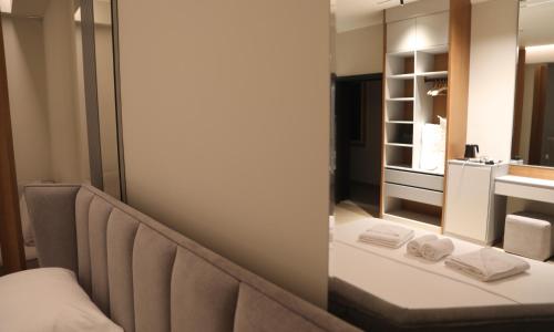 a bathroom with a bench and a mirror and a sink at Anchor Luxury Rooms in Vlorë