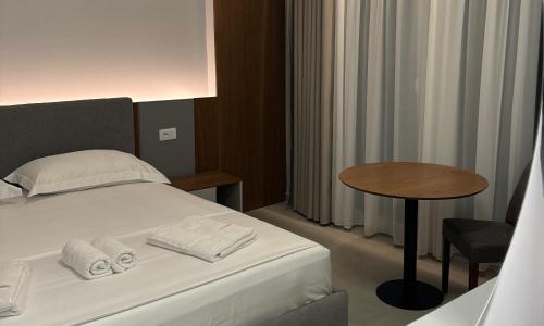 a hotel room with a bed and a table at Anchor Luxury Rooms in Vlorë