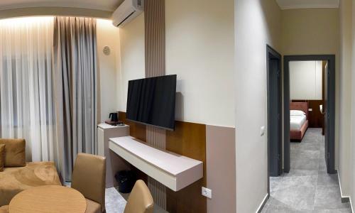 a hotel room with a sink and a tv on a wall at Anchor Luxury Rooms in Vlorë