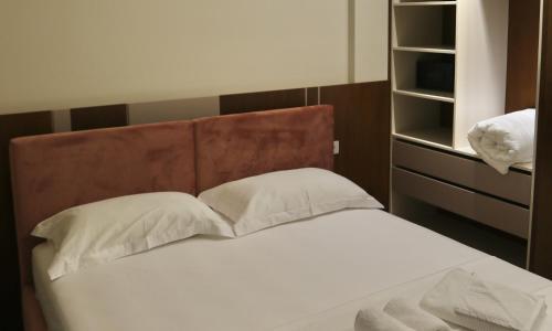 a bed with white sheets and pillows in a bedroom at Anchor Luxury Rooms in Vlorë