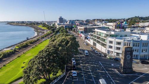 a city with a clock tower next to the ocean at West End Precinct 2 Bedroom Apartment close to walkway and ocean in New Plymouth