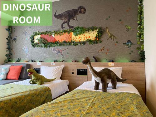 a bedroom with two beds with dinosaurs on the wall at Henn na Hotel Tokyo Nishikasai in Tokyo