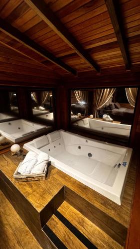 a large bath tub sitting on a wooden floor at Cabana Alpen Ville Rural com Banheira in Bom Jardim da Serra