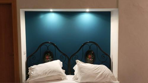 - une tête de lit bleue avec 2 oreillers blancs dans l'établissement Palazzo montagna, à Grotte