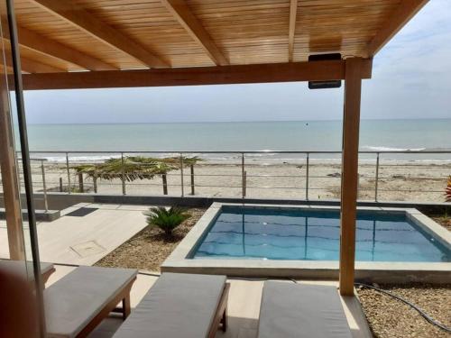 a swimming pool with a view of the beach at La Casa de David in Zorritos