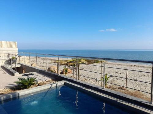 a swimming pool in front of the beach at La Casa de David in Zorritos