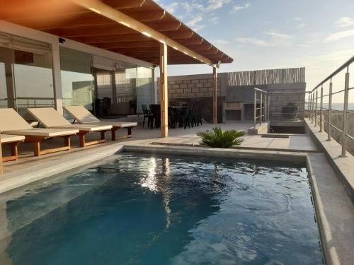 a swimming pool in the middle of a house at La Casa de David in Zorritos