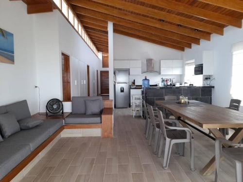 a large living room with a table and a kitchen at La Casa de David in Zorritos