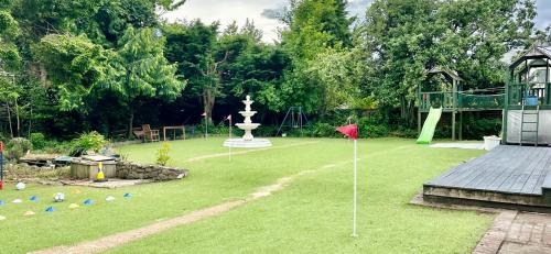 a yard with a playground with a fountain and a red flag at Edinburgh full house in Edinburgh